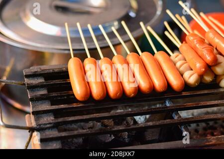 Salsiccia o hot dog alla griglia per la vendita al mercato alimentare di strada in thailandia, polpette di carne, salsiccia su spiedini pronti per la vendita, cibo tipico tailandese di strada a Bang Foto Stock