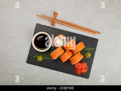 Primo piano con sei panini Philadelphia con salmone crudo serviti su tavola nera, vista dall'alto, direttamente sopra Foto Stock