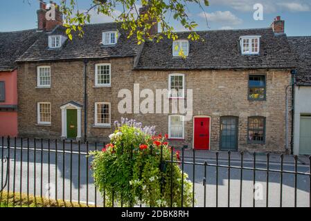 Malmesbury, Wiltshire, Inghilterra, Regno Unito. 2020. Vecchie case a Malmesbury visto attraverso le ringhiere Abbey su Gloucester Street. Foto Stock