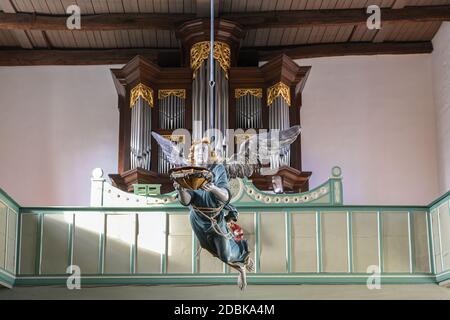 Gudow, Germania, 13 novembre 2020: Angelo barocco del battesimo in legno appeso sul soffitto di fronte all'organo nella Chiesa di Santa Maria nel villaggio o Foto Stock