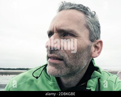 Ritratto di un uomo di mezza età che guarda scetticamente da parte Foto Stock