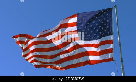 Bandiera USA sul flagpole. Bandiera americana - simbolo della libertà e del diritto negli Stati Uniti. La bandiera americana vola nel cielo come simbolo del Grande Paese degli Stati Uniti Foto Stock