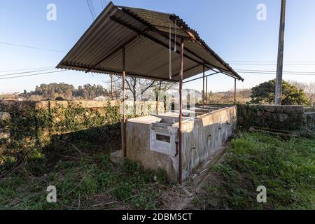 Vecchio lavatoio pubblico tradizionale fuori in un piccolo villaggio in Portogallo Foto Stock