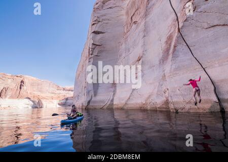 Donna che salta in acqua, Lake Powell, Utah, USA Foto Stock