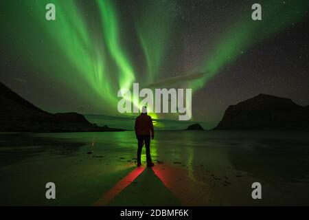 Fotografo che fotografa l'aurora boreale alla spiaggia di Vik, Vestvågøy, Isole Lofoten, Norvegia Foto Stock