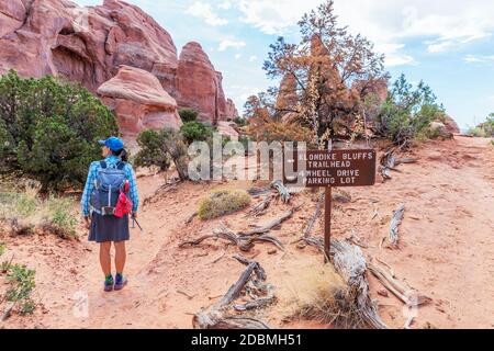 Una donna escursionista sul Tower Arch Trail, che conduce all'arco meno visitato nel Parco Nazionale delle Arches. Arches National Park è un parco nazionale nella parte orientale Foto Stock