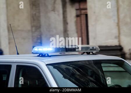 Una macchina di polizia con luci lampeggianti passa rapidamente Foto stock  - Alamy
