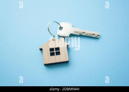 Disposizione portachiavi a forma di chiave e di casa su sfondo blu. Vista dall'alto, disposizione piatta. Immobiliare, concetto di assicurazione, ipoteca, comprare vendere casa, realtor co Foto Stock