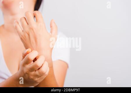 Asian bella donna che itching la sua mano useing graffio itch mano su sfondo bianco con lo spazio della copia, concetto medico e sanitario Foto Stock