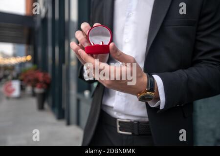 Primo piano immagine di mani mans che tengono una scatola con anello di innesto Foto Stock