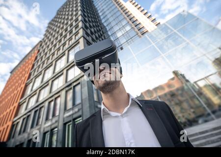 Uomo in tuta nera con occhiali vr e aspetto apprezzato Foto Stock