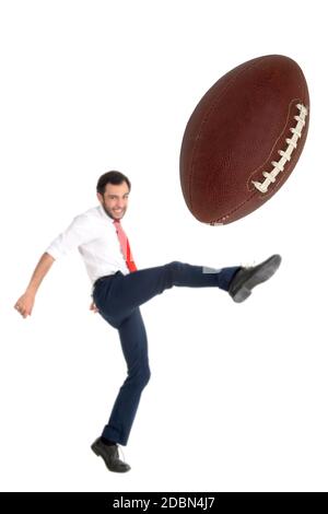 Businessman kicking aa americano calcio palla o rugby palla isolato in bianco Foto Stock