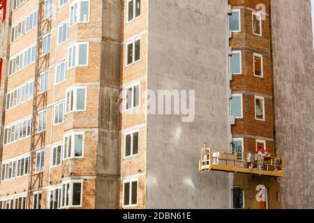 Ad alta altitudine lavorare sulle pareti esterne di isolante in lana di vetro e gesso Foto Stock