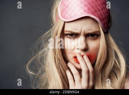 donna con maschera rosa sulla testa, rossetto rosso sbavato su tutto il viso Foto Stock