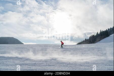 Il ragazzo sciatore che va veloce scende lungo la collina di montagna. Immagine del concetto di sport invernale attivo. Foto Stock