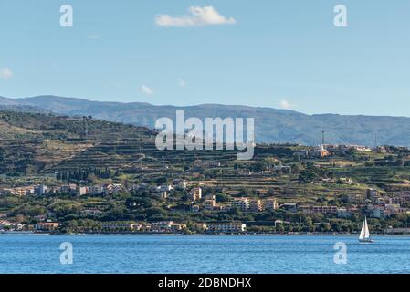 Lo stretto di Messina collegai il Mar Mediterraneo e il Tirreno e l'isola Sicilia con cielo blu e costa come sfondo, vista dal lungomare banchina wa Foto Stock