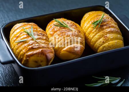 Patate Hasselback. Patate a filetto dalla Svezia con aglio ed erbe grigliate nel forno. Foto Stock