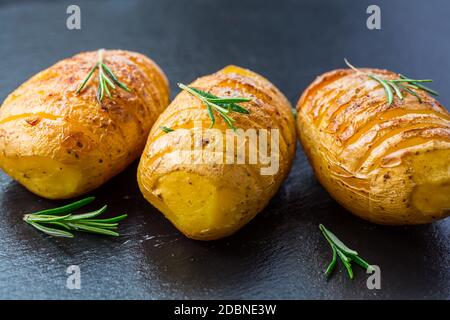 Patate Hasselback. Patate a filetto dalla Svezia con aglio ed erbe grigliate nel forno. Foto Stock