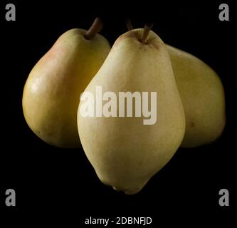 tre pere mature e succose su sfondo nero Foto Stock