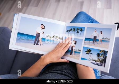 Donna che guarda un album fotografico o un album fotografico Foto Stock