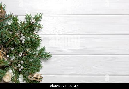 Rami di pino con ornamenti di Capodanno su sfondo bianco di legno. Spazio di copia, modello Foto Stock