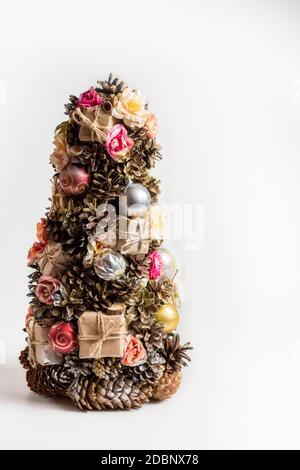 Abete di Natale fatto in casa in stile rustico coni di pino, noci, giocattoli isolati Foto Stock