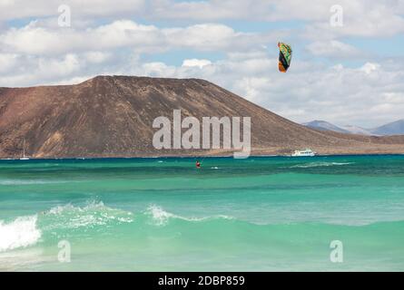 CORRALEJO, FUERTEVENTURA, SPAGNA - 15 SETTEMBRE 2015: Kitesurfer sconosciuto surfing su un'acqua piatta azzurra dell'oceano Atlantico a Corralejo, Fuerteventura, Foto Stock