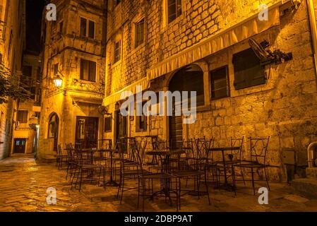 Caffetteria all'aperto su una strada illuminata nella città vecchia di Cattaro di notte, Montenegro Foto Stock