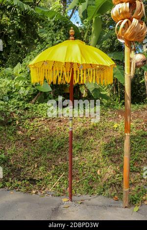 Decorazione del complesso tempiale indù Batukaru sull'isola di Bali in Indonesia. Ombrelli decorativi gialli e bianchi che percorrono il percorso per i visitatori credenti. C Foto Stock