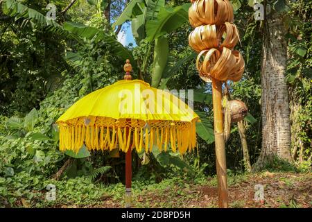 Decorazione del complesso tempiale indù Batukaru sull'isola di Bali in Indonesia. Ombrelli decorativi gialli e bianchi che percorrono il percorso per i visitatori credenti. C Foto Stock