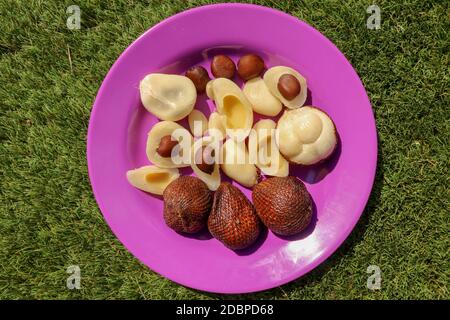 Primo piano di pezzetti di frutta di serpente sbucciati, cutati e interi con semi. Vista dall'alto della frutta sana. Salak pondoh è una delle cultivar di salak che principalmente Foto Stock