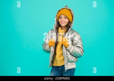 happy kid in giacca e maglieria color argento si scalda in inverno pronto per attività in vacanza, moda invernale. Foto Stock