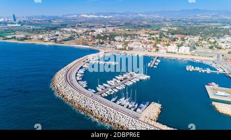Antenna ad occhio d'uccello del Zygi villaggio di pescatori porto, Larnaca, Cipro. Il pesce barche ormeggiate nel porto di yacht ancorati e sullo skyline della città Foto Stock