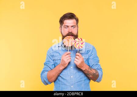 Non lasci la fame accadere a voi. Hipster sorpreso guardare lollipop. Gustando uno spuntino caramella. Cibo malsano e snacking. Dieta e dieta. Spuntino dolce. Dessert. Negozio di caramelle. Raddoppia il tuo piacere. Foto Stock