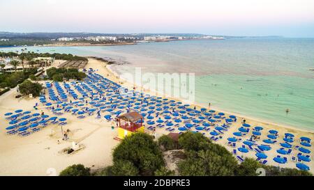 Vista aerea dall'alto della famosa spiaggia di Makronissos, Ayia Napa, Famagosta, Cipro. L'attrazione turistica principale della baia di Makronisos al tramonto w Foto Stock