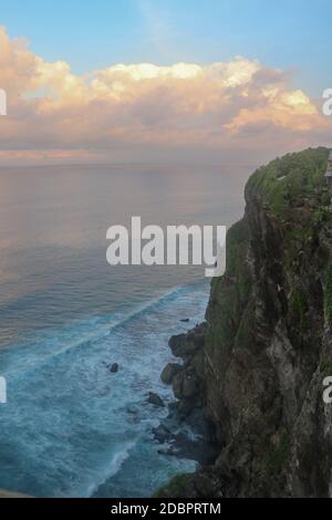 Splendida vista panoramica di un luogo famoso e iconico, il Tempio di Uluwatu, durante un'alba estiva vibrante. Viste incredibili al tempio di pura Luhur Uluwatu a Bal Foto Stock