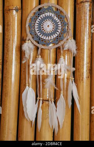 Blue Dreamcatcher con piume e perline isolate su uno sfondo wodden. Foto Stock
