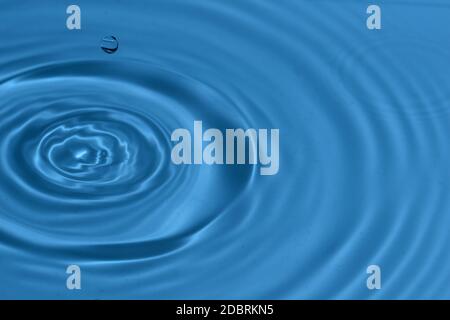 Texture di sfondo, con la caduta di gocce di acqua e onde con acqua blu Foto Stock