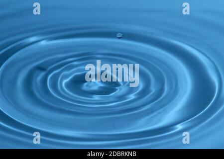 Texture di sfondo, con la caduta di gocce di acqua e onde con acqua blu Foto Stock