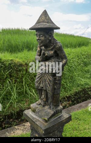 Statua di un coltivatore di riso vicino al campo di riso. Villaggio balinese di Jatiluwih. Bali, Indonesia. Foto Stock