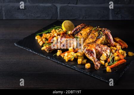 Pollo intero alla griglia con verdure arrosto e patate. Stile pollo roadkill con erbe e limone. Foto Stock