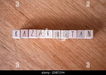Il paese Kazakhstan scritto su cubetti di legno su sfondo di legno texture Foto Stock