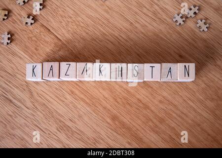 Il paese Kazakhstan scritto su cubetti di legno su sfondo di legno texture Foto Stock