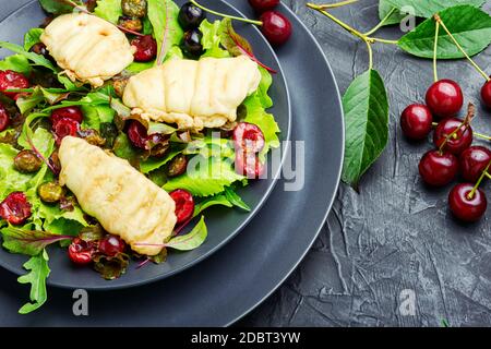 Insalata estiva di lattuga a foglia, formaggio halloumi fritto e bacche di ciliegia Foto Stock