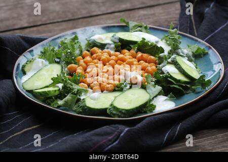 Insalata vegetariana sana con ceci arrostiti, kale, cetriolo e condimento. Disintossicazione sana. Cibo vegetariano e vegano. Foto Stock