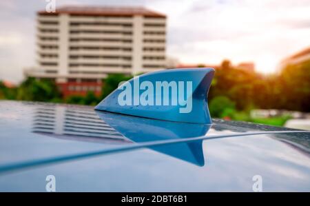 Antenna senza fili con pinna di squalo per auto da closeup sul tetto blu. Antenna GPS a forma di pinna di squalo su un'auto per sistema di radionavigazione. Antenna radio AM/FM per auto. Foto Stock