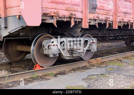 Il treno è fermo con un cavalletto. Sfondo ferroviario. Treno merci, tema ferroviario. Sistema di trasporto, servizio di carico. Foto Stock