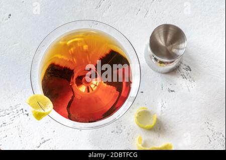 Bicchiere di cocktail Martinez guarnito con scorza di limone Foto Stock