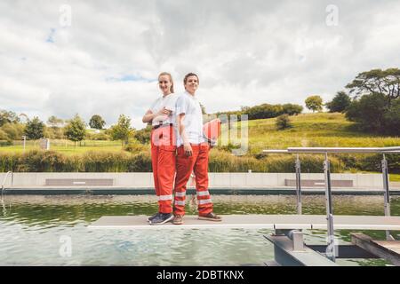 Bagnini in piedi sulla piscina pronti ad aiutare Foto Stock