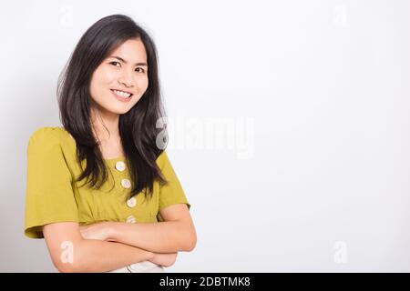 Ritratto asiatico bella giovane donna in piedi sorriso vedere denti bianchi, ha attraversato le braccia e guardando la fotocamera, scattare foto in studio su bianco bac Foto Stock